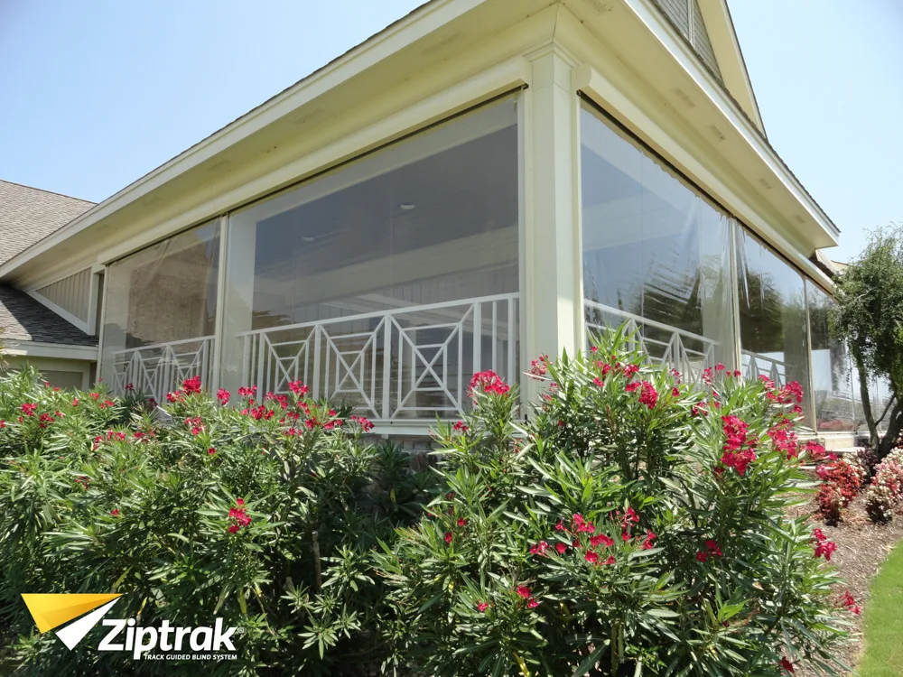 Outdoor living space protected by clear PVC Ziptrak blinds.