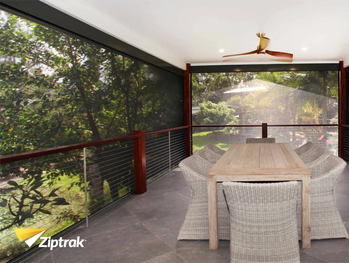 Ziptrak outdoor blinds protecting an alfresco setting from wind-driven rain during a storm.